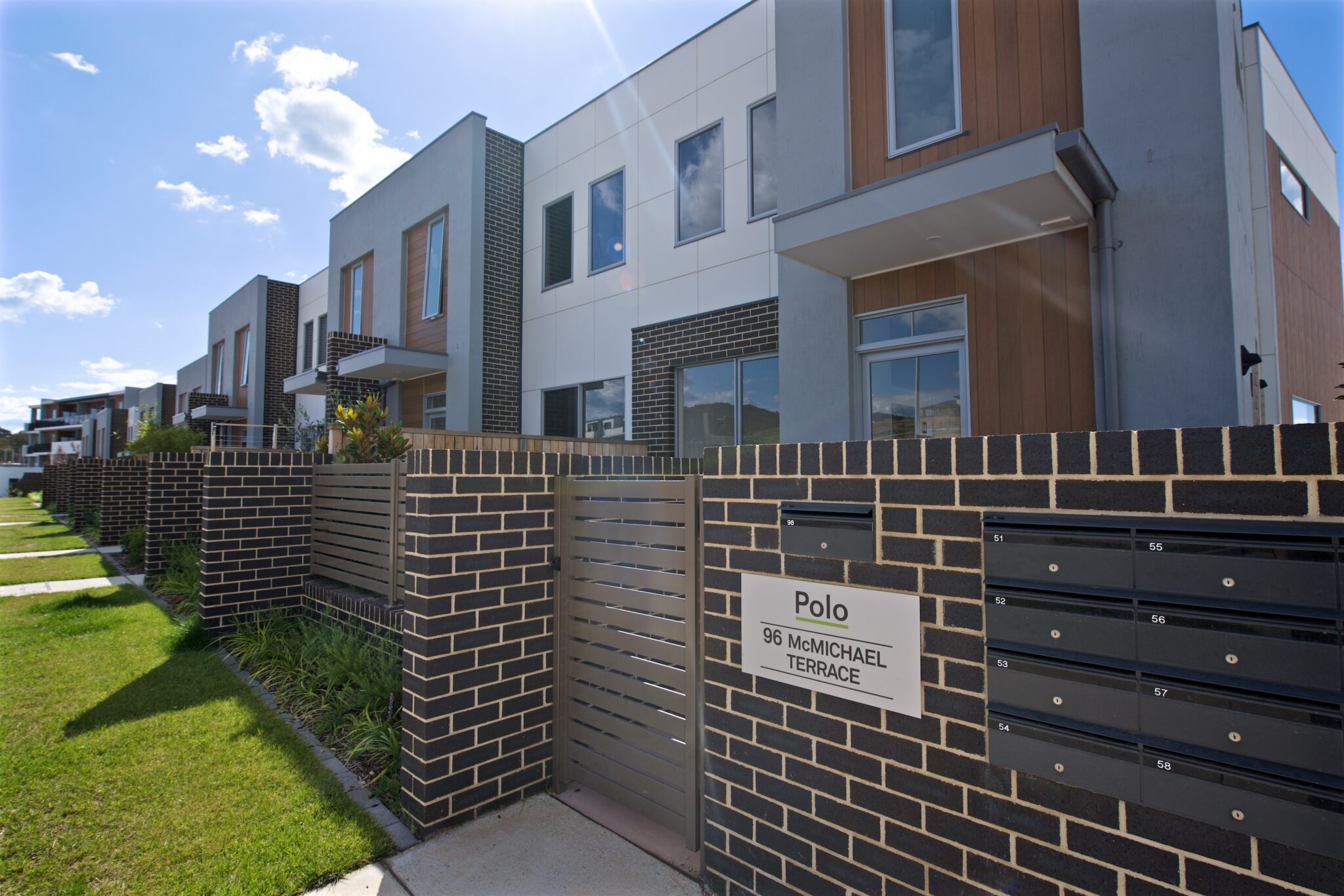 Polo townhouses mid shot west view with name plate Milin Builders